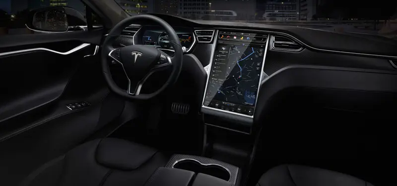 Tesla Model S interior: black dashboard and large central touchscreen showing a map