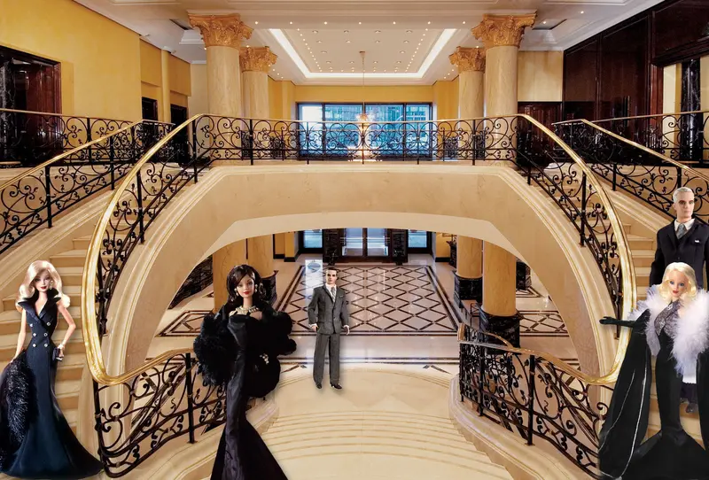 Barbie and Ken dolls in evening wear posed in a grand marble foyer with sweeping gilded staircases