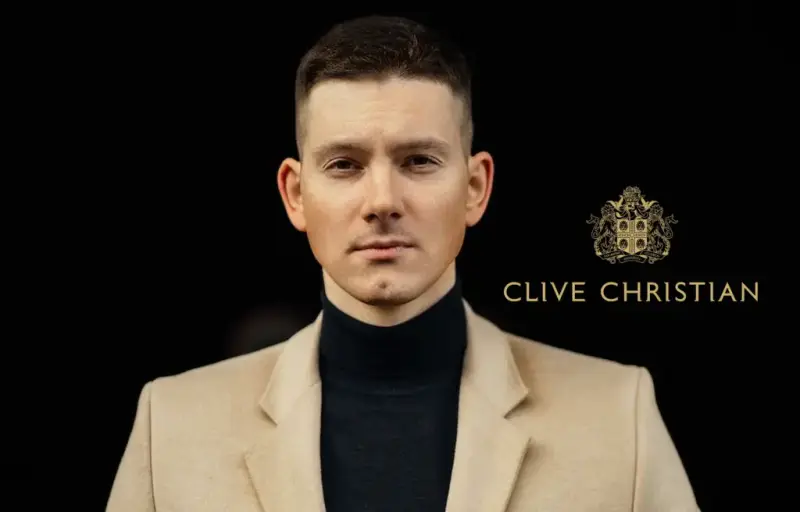 Clive Christian perfume advertisement: a man in a camel coat and black turtleneck beside the Clive Christian crest